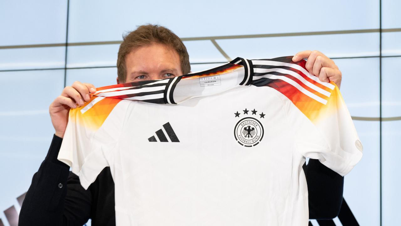 Bundestrainer Julian Nagelsmann hält auf einer Pressekonferenz das neue offizielle EM-Trikot des DFB-Teams hoch.