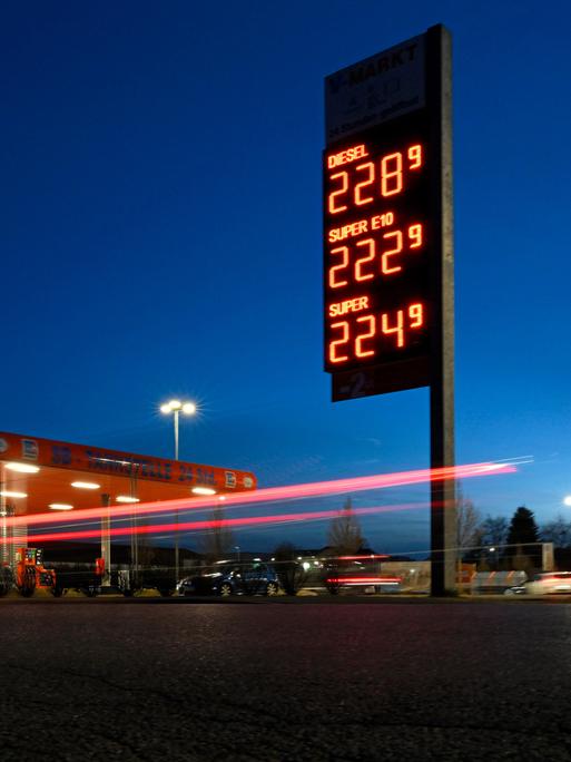 Die Spritpreis-Tafel an einer Tankstelle leuchtet nachts und zeigt hohe Benzin- und Dieselpreise.