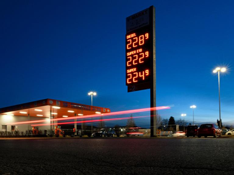 Die Spritpreis-Tafel an einer Tankstelle leuchtet nachts und zeigt hohe Benzin- und Dieselpreise.