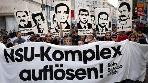 Mehrere tausend Menschen, unter Ihnen Angehoerige der Opfer der rechtsextremen Terrorgruppe NSU protestiern nach der Urteilsverkuendung im NSU-Prozess. Sie tragen ein Plakat mit der Aufschrift "NSU-KOmplex auflösen!" und Bilder der Ermordeten. 