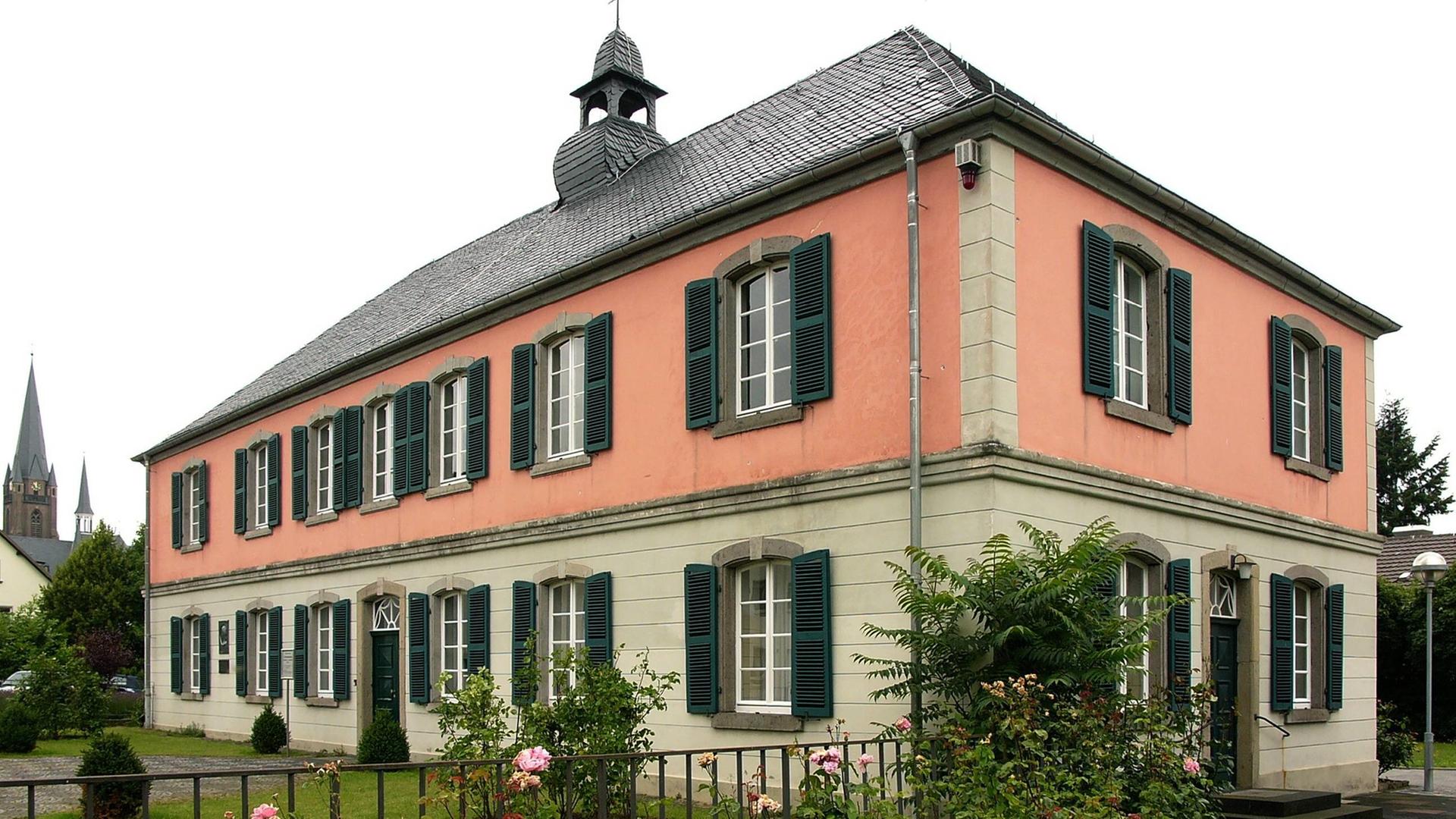 Ein Haus mit rosa Putz und grünen Fensterläden und einem kleinen Mitteltürmchen gehörte früher zu einer Nervenheilanstalt, in der Robert Schumann 1856 verstarb. 