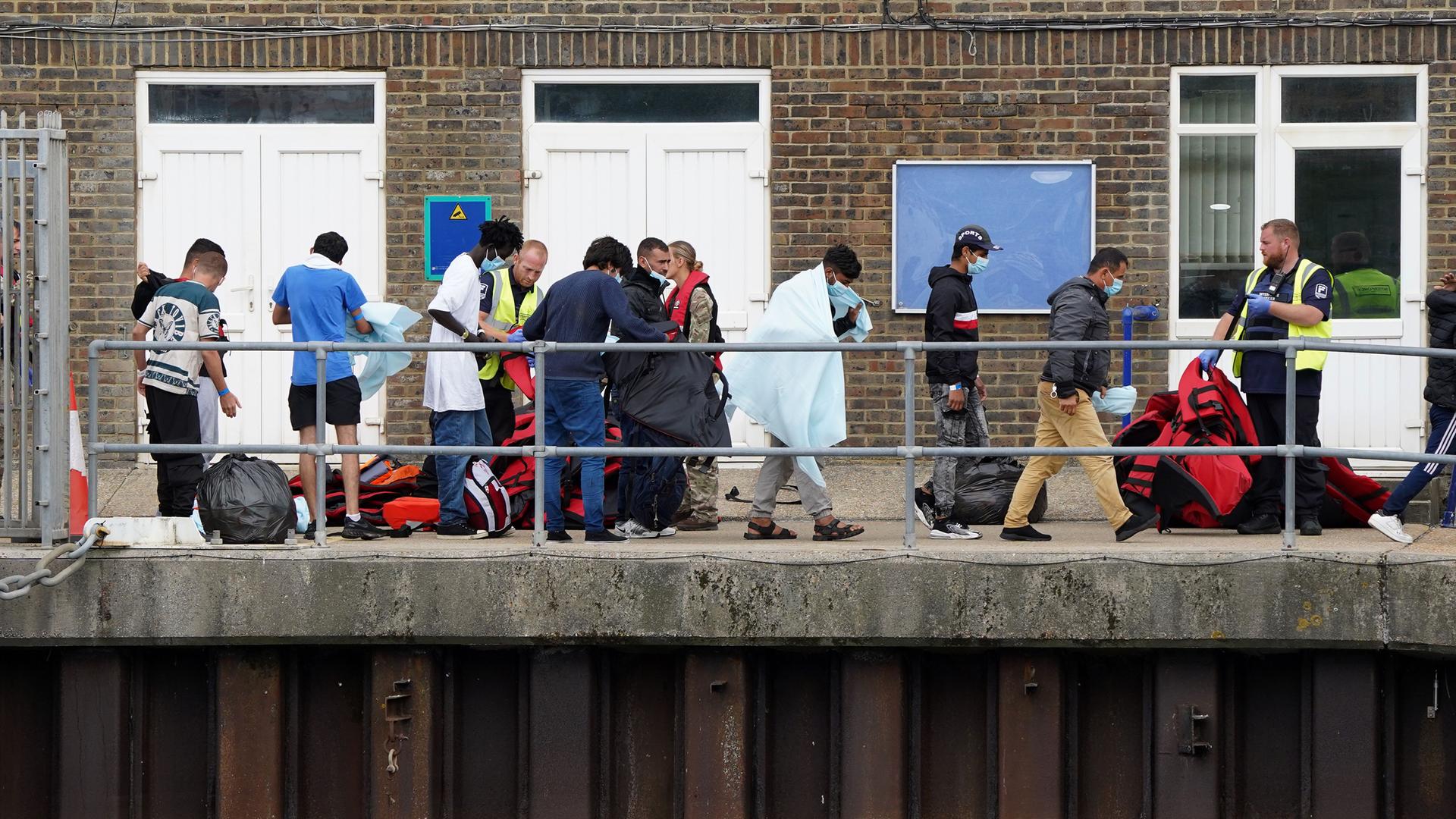 Eine Gruppe von Menschen, bei denen es sich vermutlich um Migranten handelt, wird nach einem Zwischenfall mit einem kleinen Boot im Ärmelkanal von einem Schiff der Border Force nach Dover gebracht.