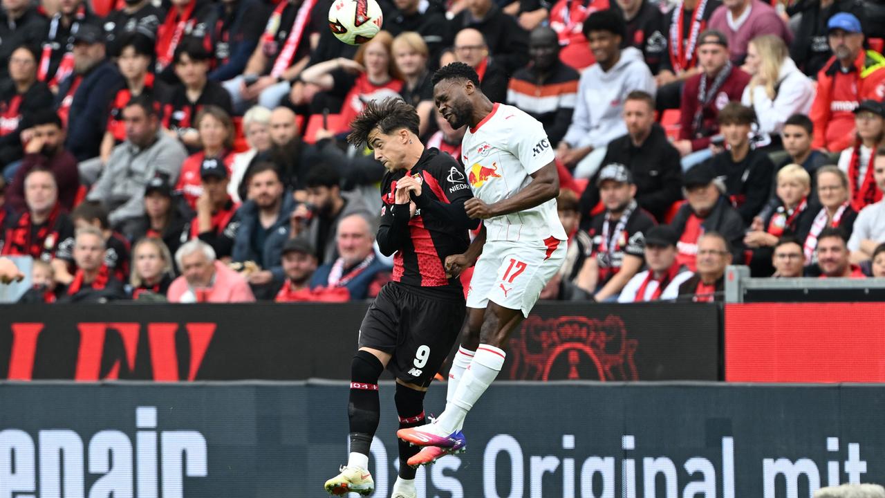 Die Fußballer Afonso Moreira (Bayer Leverkusen) und Ridle Baku (RB Leipzig) steigen im Zweikampf zu einem Kopfball hoch.