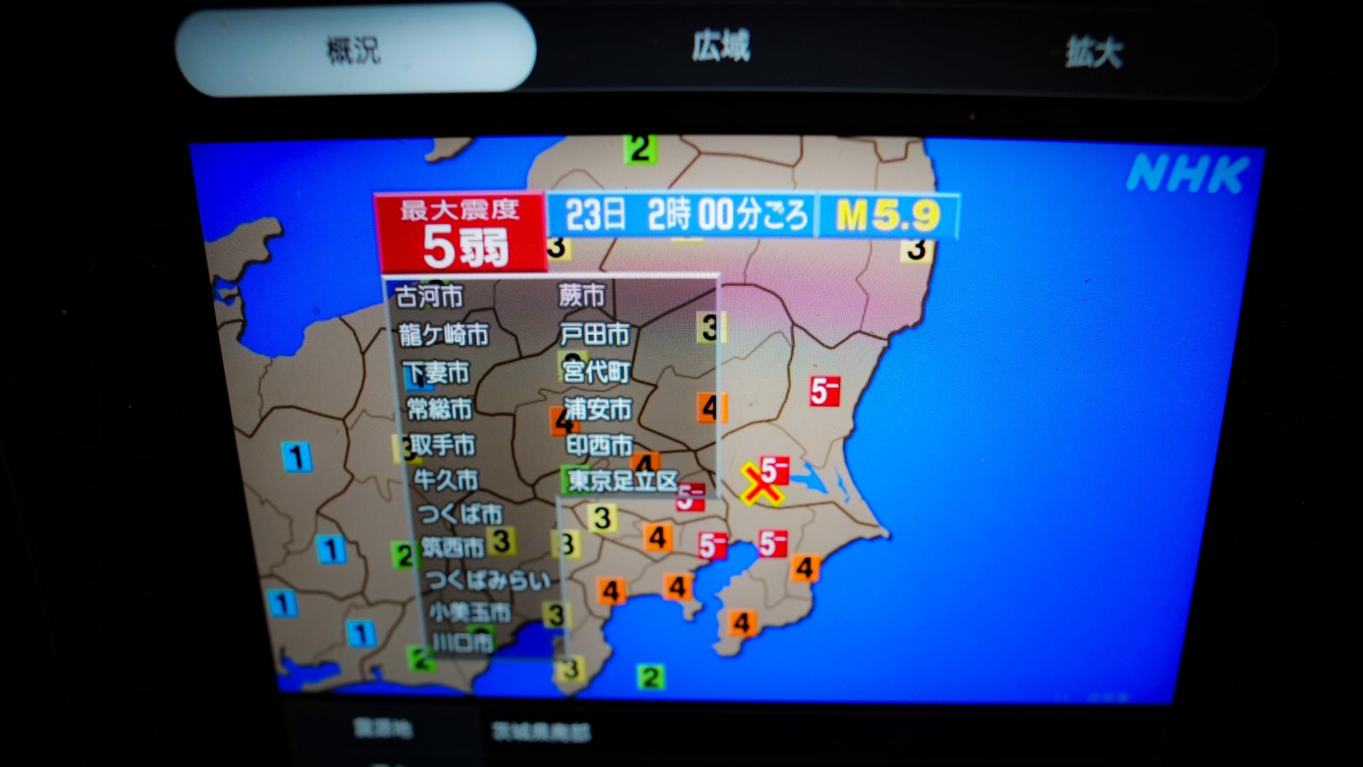 Auf einen Bildschirm werden mit Informationen zum Erdbeben in Japan gezeigt. 