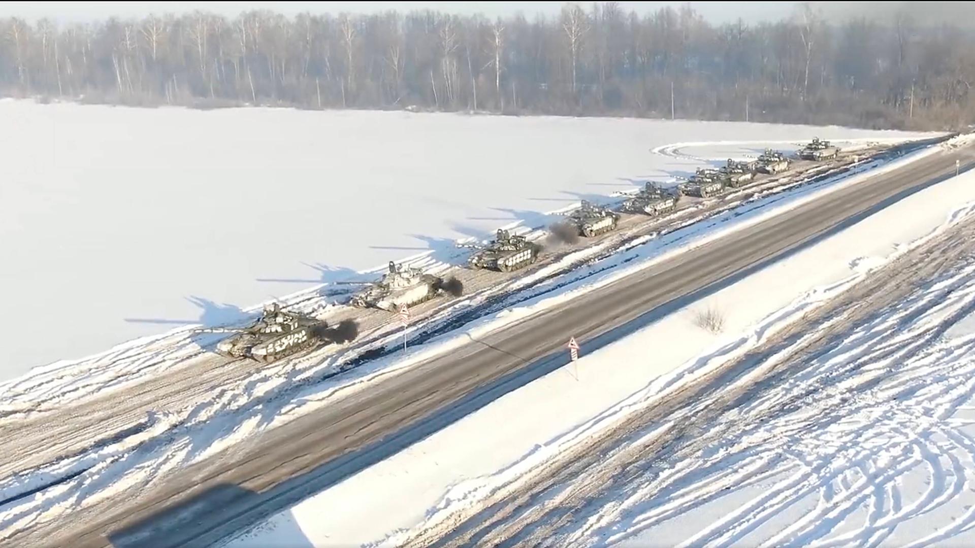 Russische Panzer fahren hintereinander durch eine Schneelandschaft.