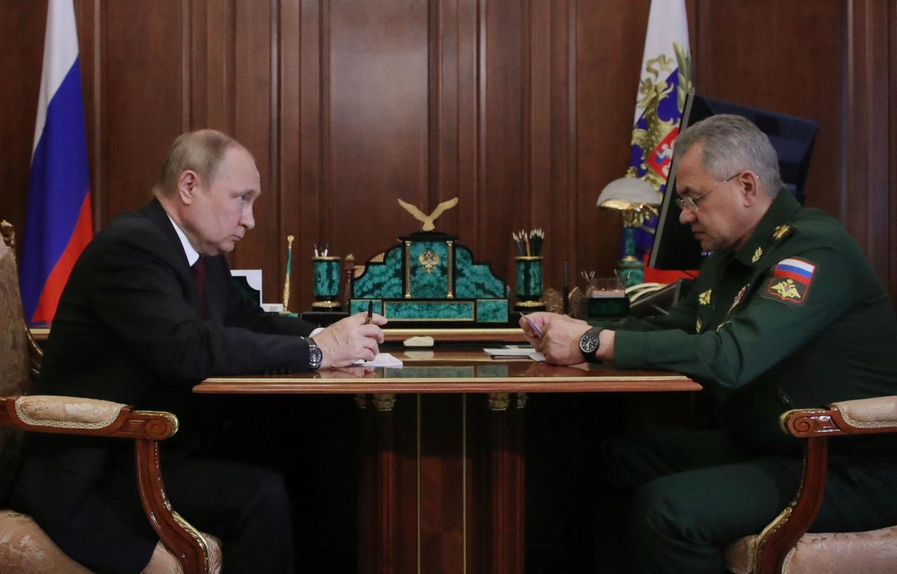Der russische Präsident Putin und Verteidigungsminister Shoigu sitzen sich an einem Tisch im Kreml gegenüber.