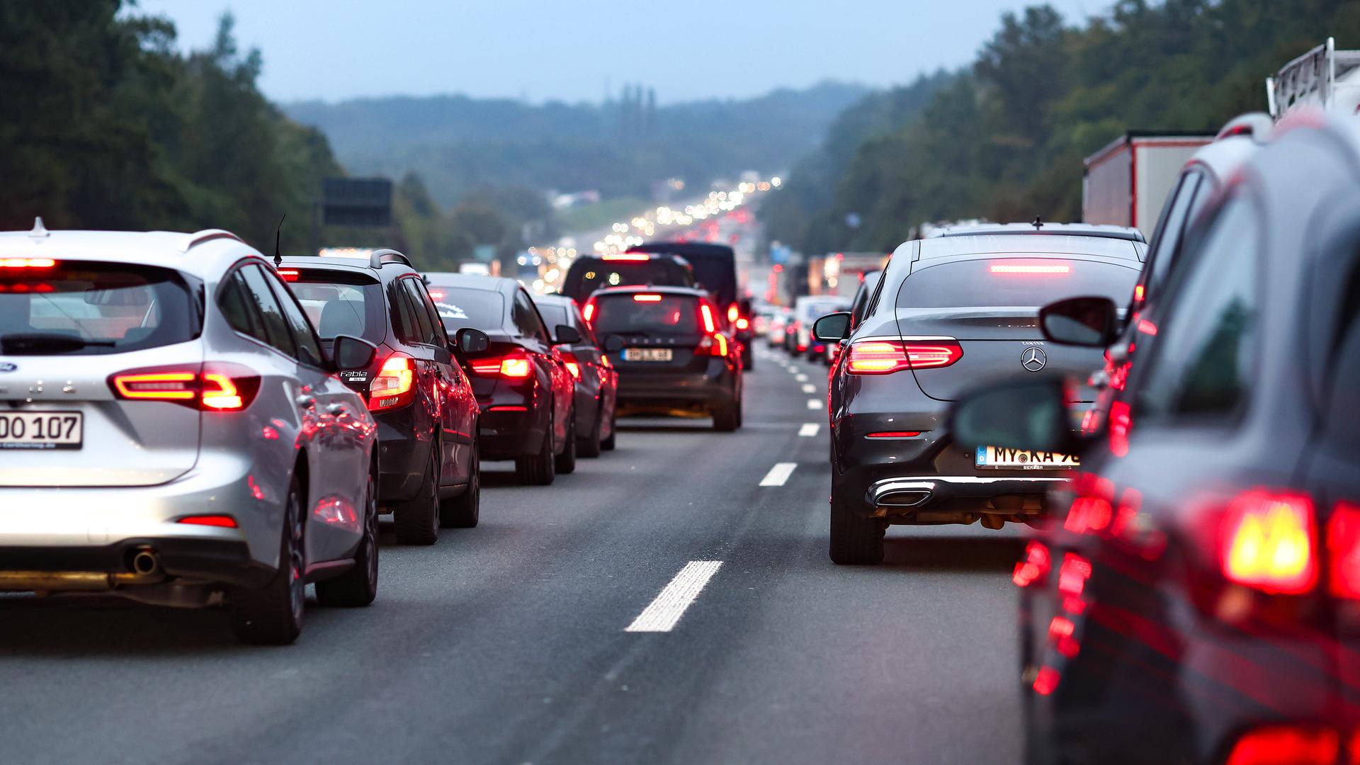 Autos stehen auf einer Autobahn. Zwischen den Reihen ist eine Retttungsgasse gebildet worden. Auch von der Landschaft ist etwas zu sehen. Am Horizont gibt es ein Stück davon.