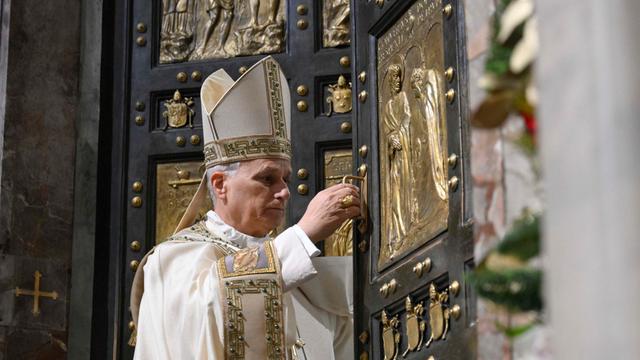 Das Foto zeigt Papst Leo in einem weißen Gewand. Er schließt die Heilige Pforte im Peters-Dom wieder ab. 