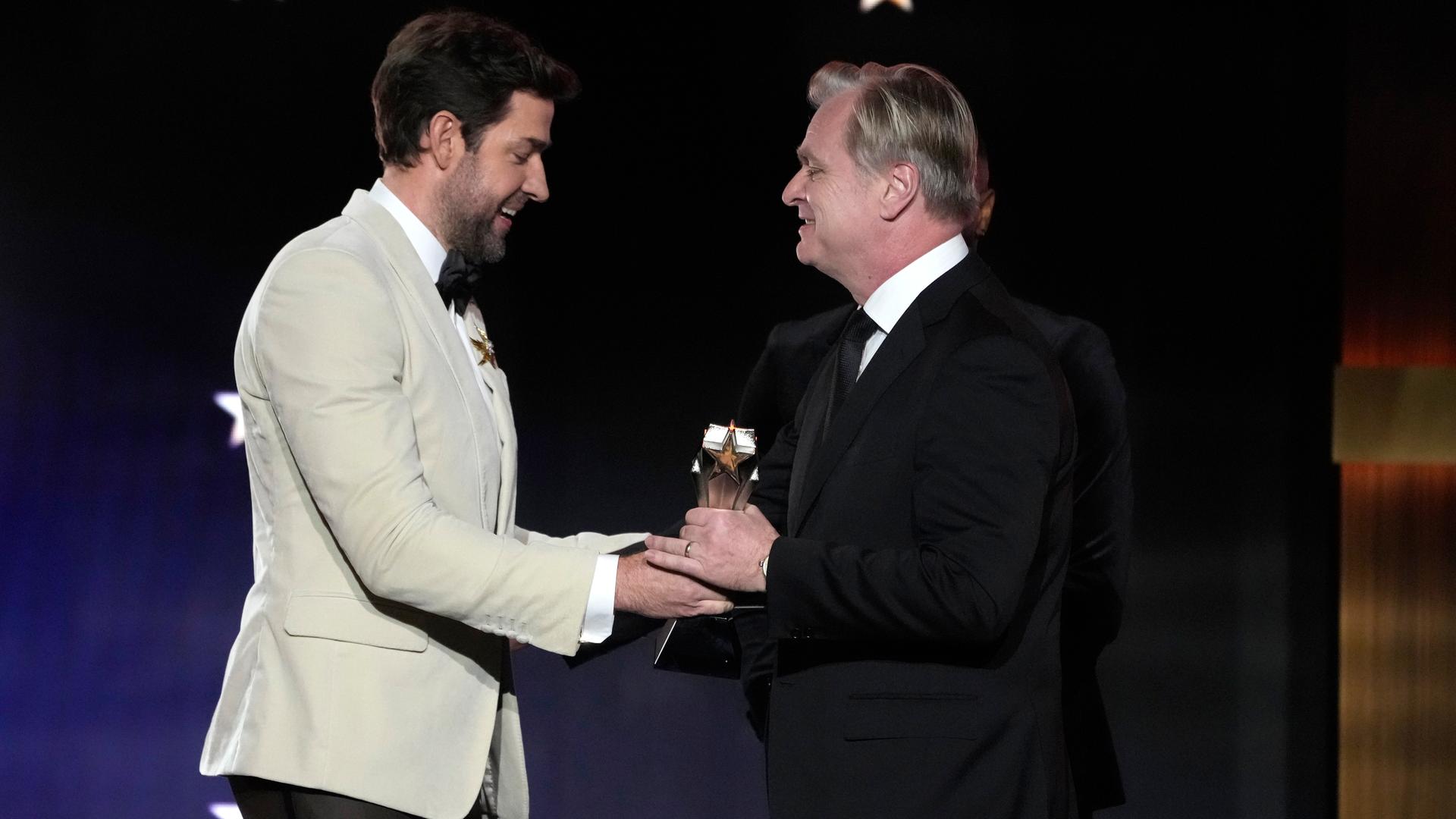 Christopher Nolan nimmt den Preis für die Regie beim Film "Oppenheimer" vom Laudator John Krasinski entgegen. Christopher Nolan nimmt den Preis für die Regie beim Film "Oppenheimer" vom Laudator John Krasinski entgegen.