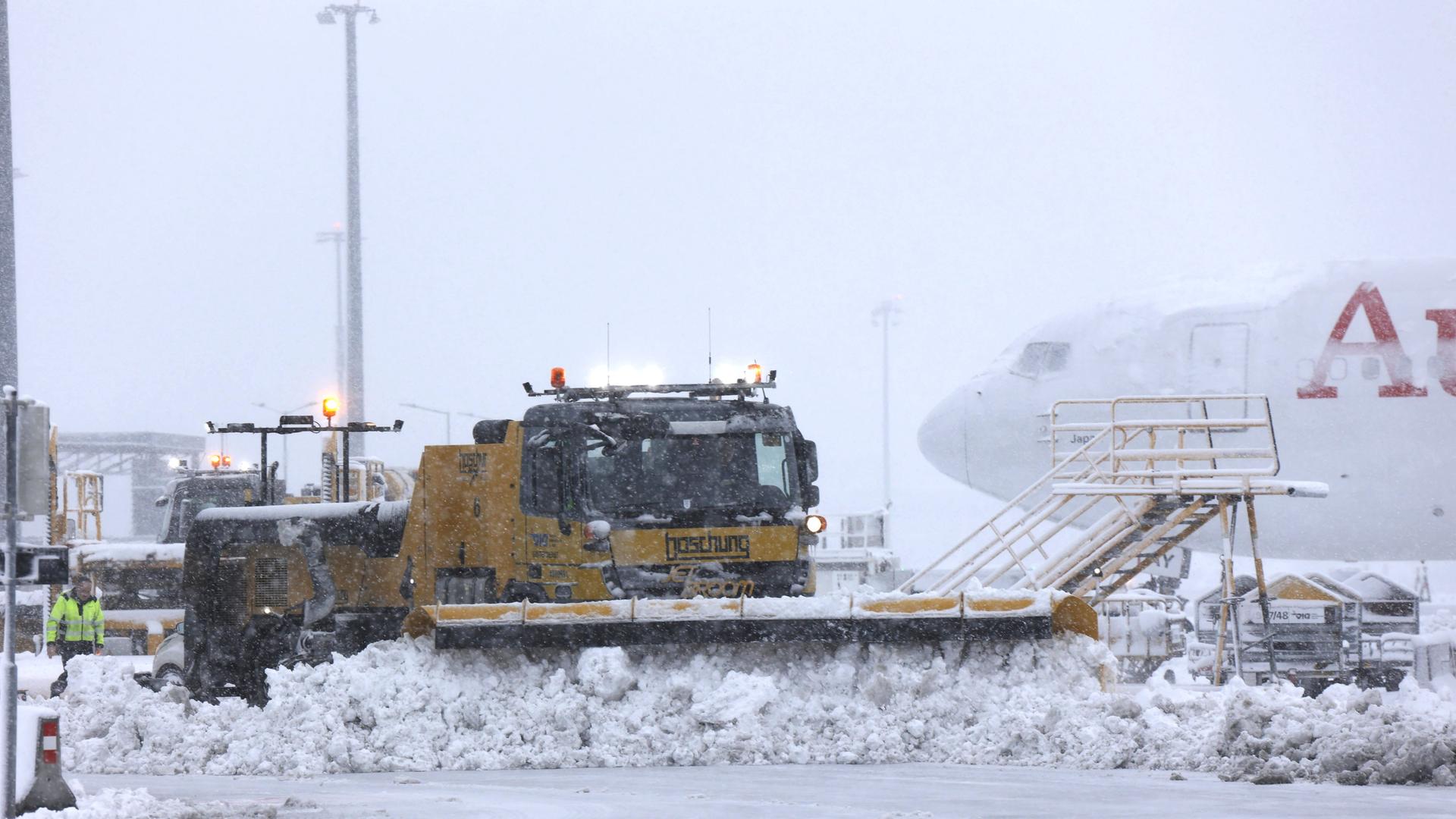 Ein Räumfahrzeug am Flughafen Wien schiebt Schnee beiseite. 
