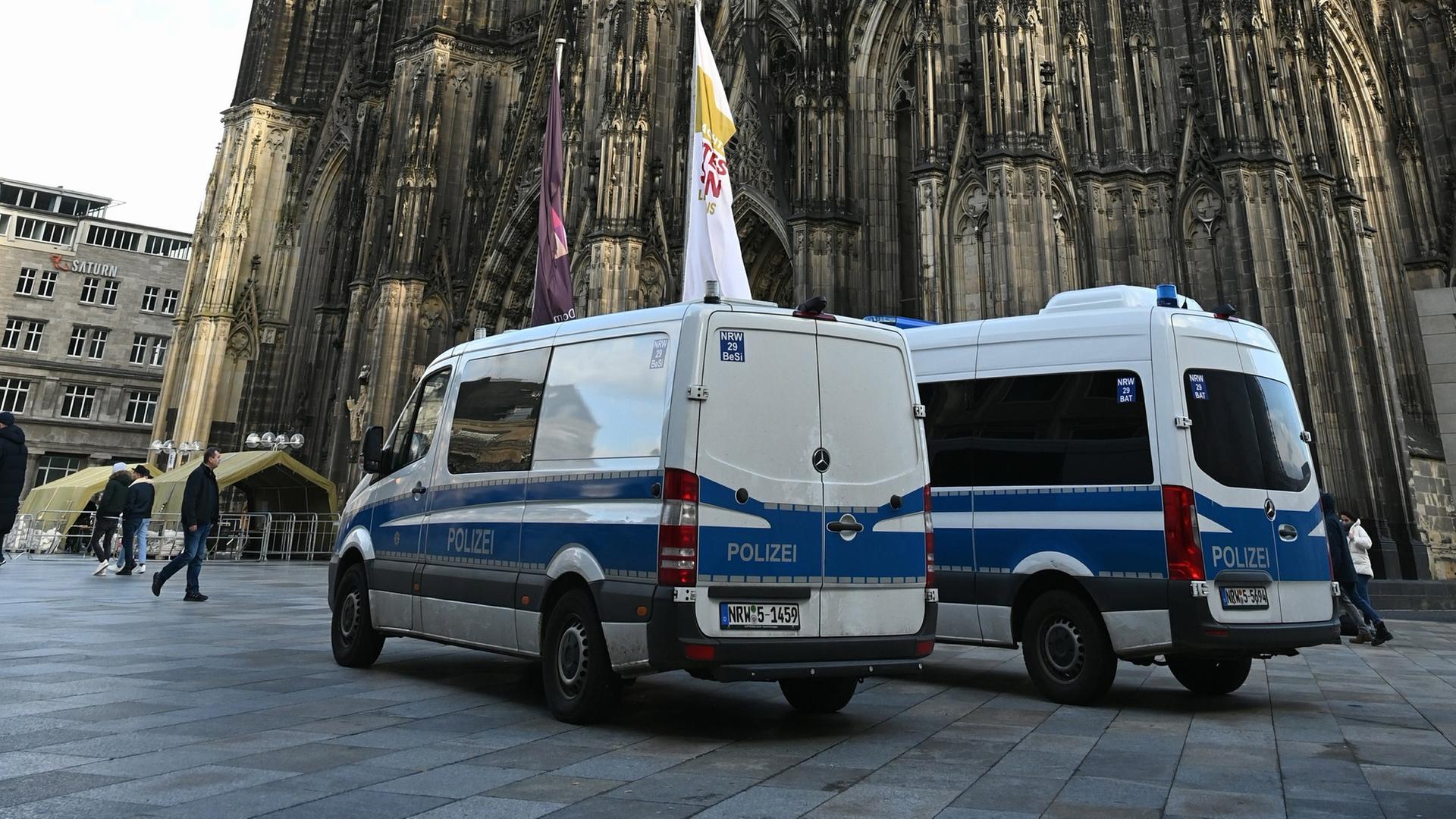 Polizisten und Polizeiwagen stehen vor dem Kölner Dom. Nach einer Terrorwarnung wurden die SicherheitsmaÃnahmen am Kölner Dom erhöht. Er gilt als mögliches Angriffsziel der Terroristen.