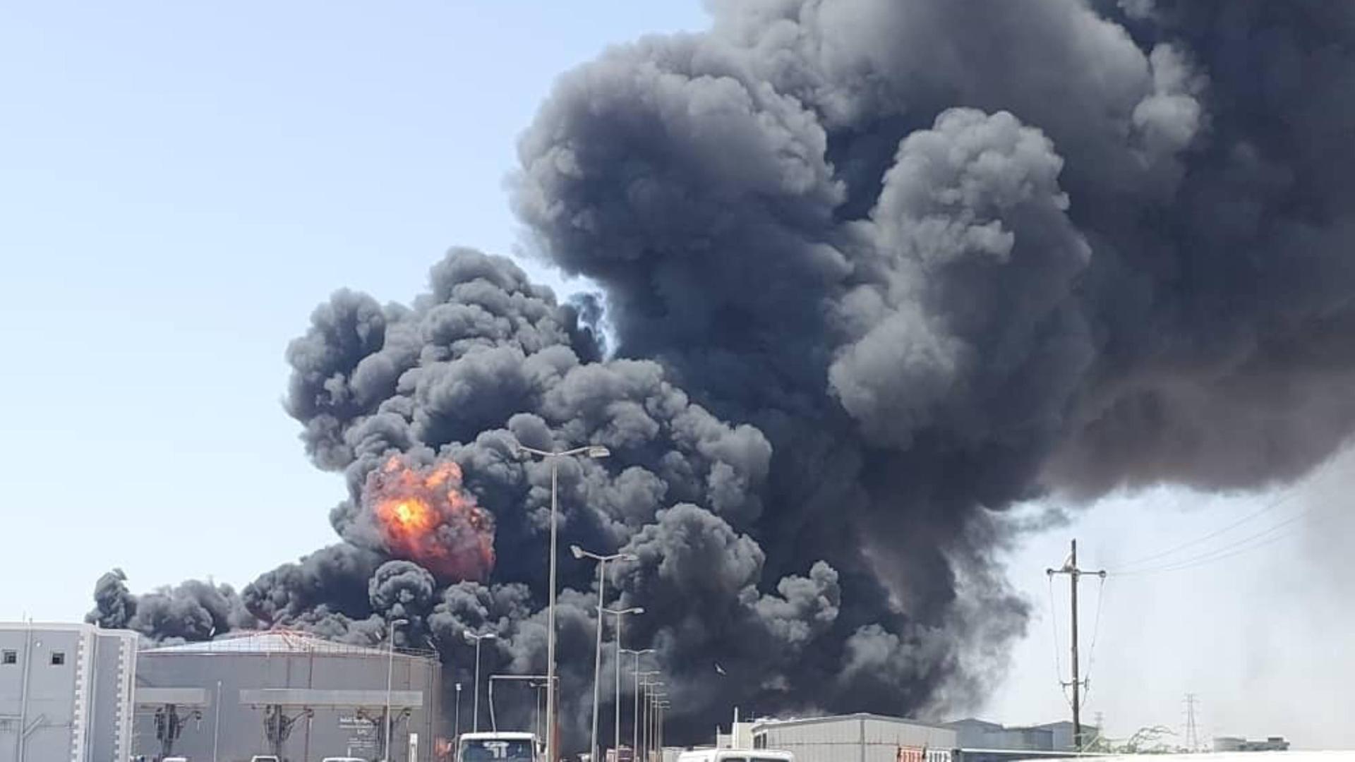 Eine tiefdunkle riesige Rauchwolke steigt über einem Treibstoffdepot auf. An einer Stelle ist in dem Rauch auch Feuer zu erkennen.