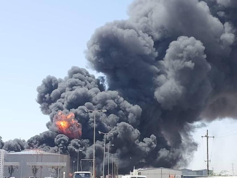 Eine tiefdunkle riesige Rauchwolke steigt über einem Treibstoffdepot auf. An einer Stelle ist in dem Rauch auch Feuer zu erkennen.