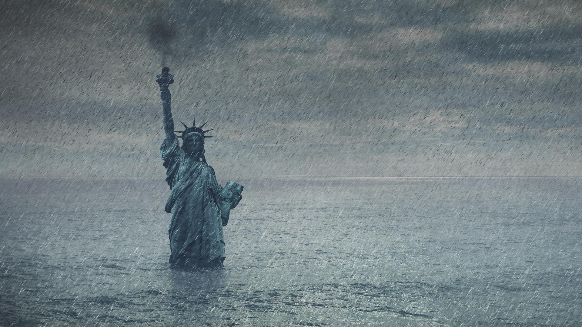 Eine Fotomontage/Illustration der Freiheitsstatue in New York. Es regnet und die Statue geht im Hochwasser unter.