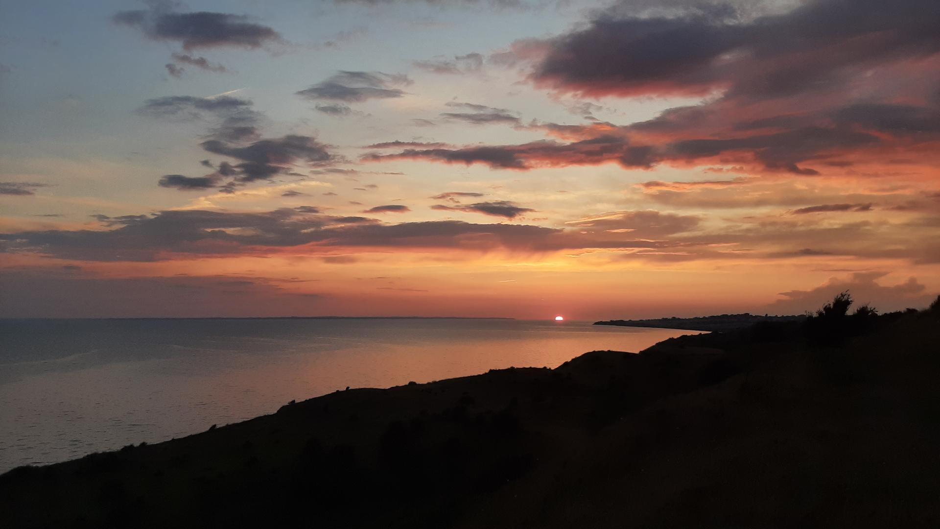 Ein Sonnenuntergang mit vielen orangefarbenen Tönen. 