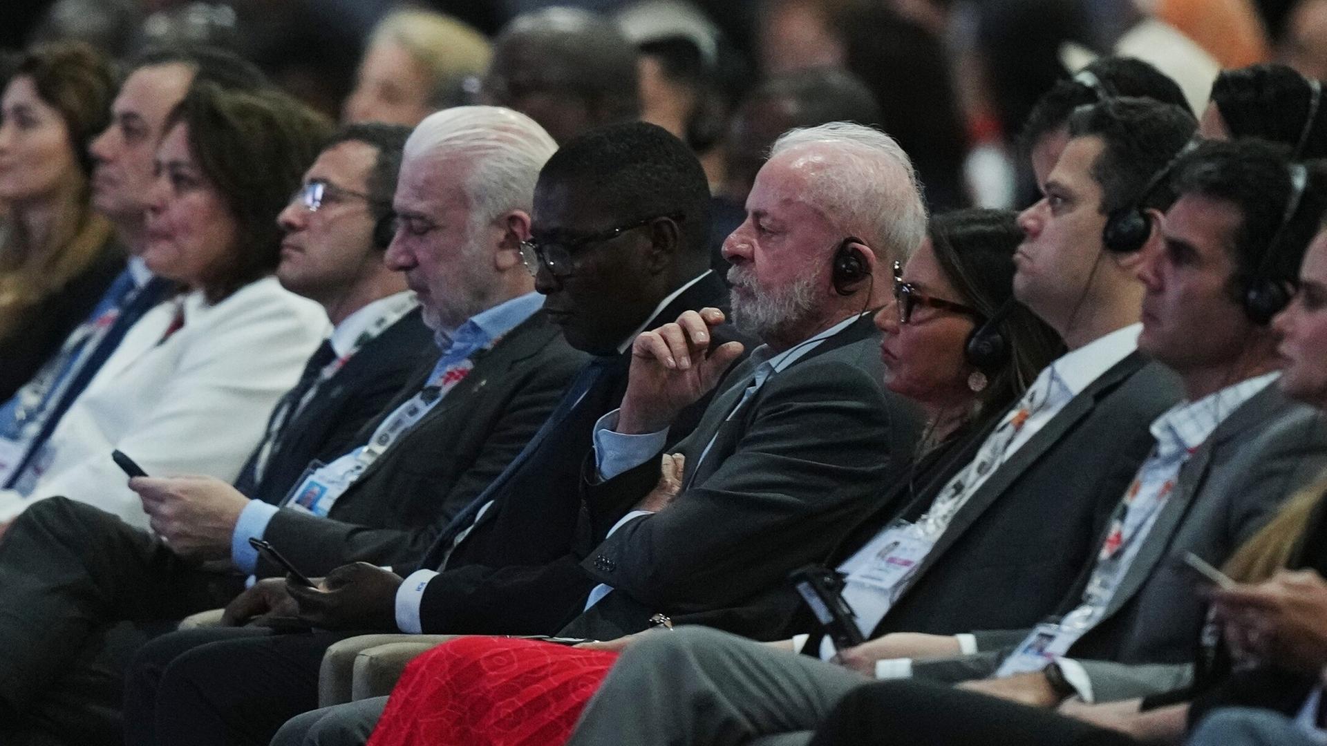 Mehrere Delegierte sitzen auf der Weltklimakonferenz nebeneinander. 