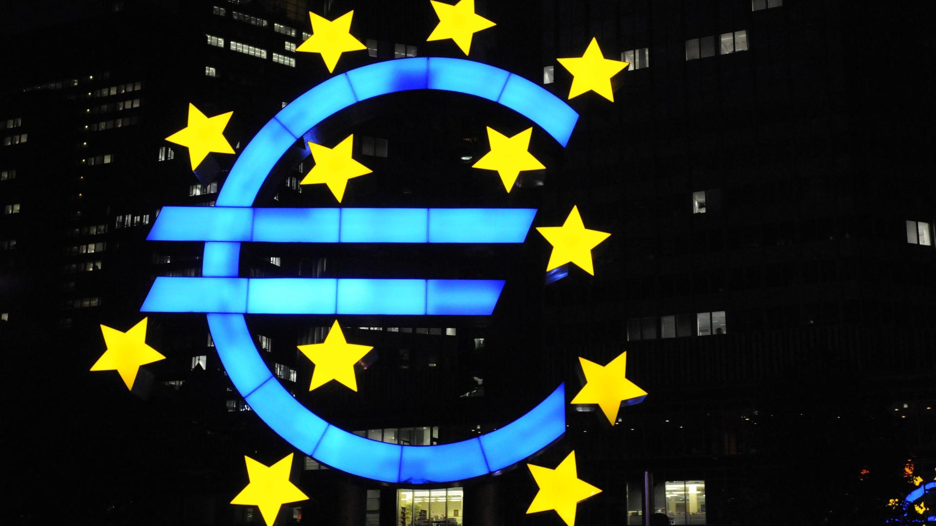 Das Euro-Zeichen, das sich vor der Europäischen Zentralbank in Frankfurt befindet, leuchtet in der Nacht
