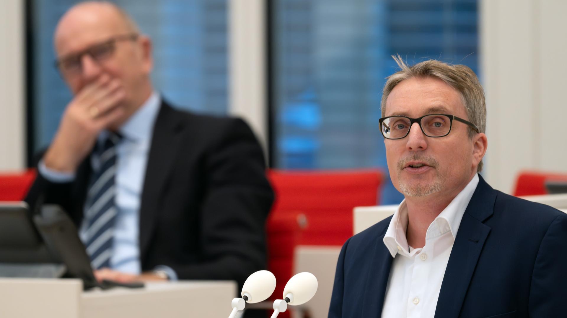 SPD-Fraktionschef Björn Lüttmann (r.) spricht während einer Sitzung des Brandenburger Landtags am Rednerpult. Hinter ihm sitzt Dietmar Woidke, Ministerpräsident von Brandenburg.