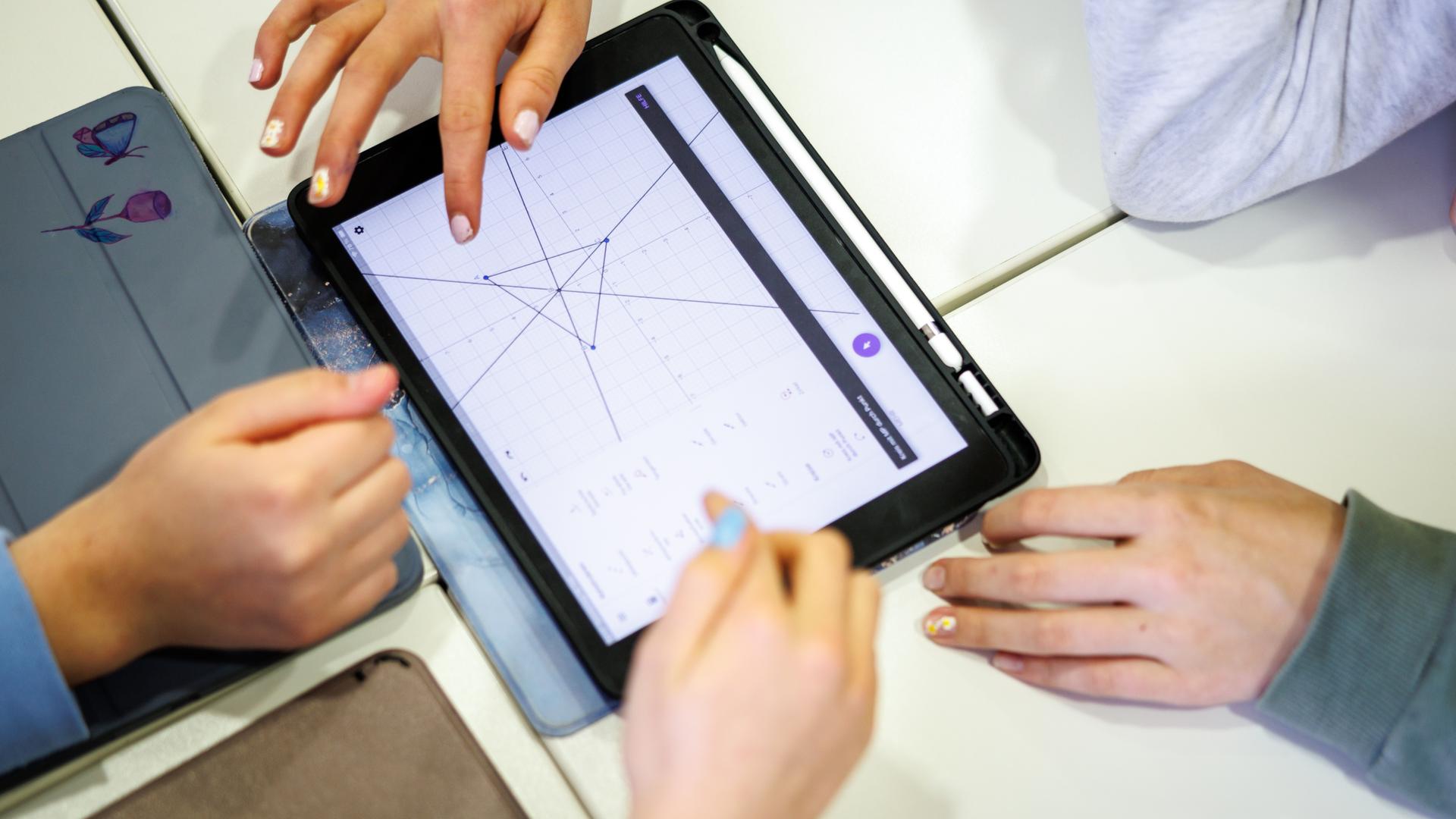 Schülerinnen einer siebten Klasse arbeiten in einem Klassenraum am Oskar-Maria-Graf-Gymnasium in Neufahrn in einer Unterrichtsstunde im Fach Mathe in einer Lerngruppe gemeinsam an einem Tablet. Schülerinnen einer siebten Klasse arbeiten in einem Klassenraum am Oskar-Maria-Graf-Gymnasium in Neufahrn in einer Unterrichtsstunde im Fach Mathe in einer Lerngruppe gemeinsam an einem Tablet.