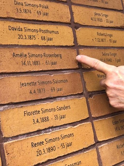 Mauer mit Namen der Holocaust Opfer am Mahnmal Amsterdam, Gaby Glassman hat den Namen ihrer Großmutter gefunden, Amelie Simons-Rosenberg, eine ihrer vier Großeltern, alle am gleichen Tag umgebracht im KZ Sobibor 