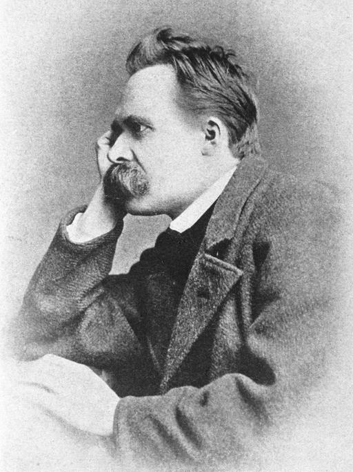 Porträt des Philosophen Friedrich Nietzsche, der seinen Kopf auf seine rechte Hand stützt und grübelnd ins Off des Bildes blickt.