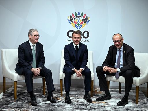 Der britische Premierminister Keir Starmer (links), Frankreichs Präsident Emmanuel Macron (Mitte) und Bundeskanzler Friedrich Merz lächeln für die Kameras beim G20-Gipfel in Johannesburg
