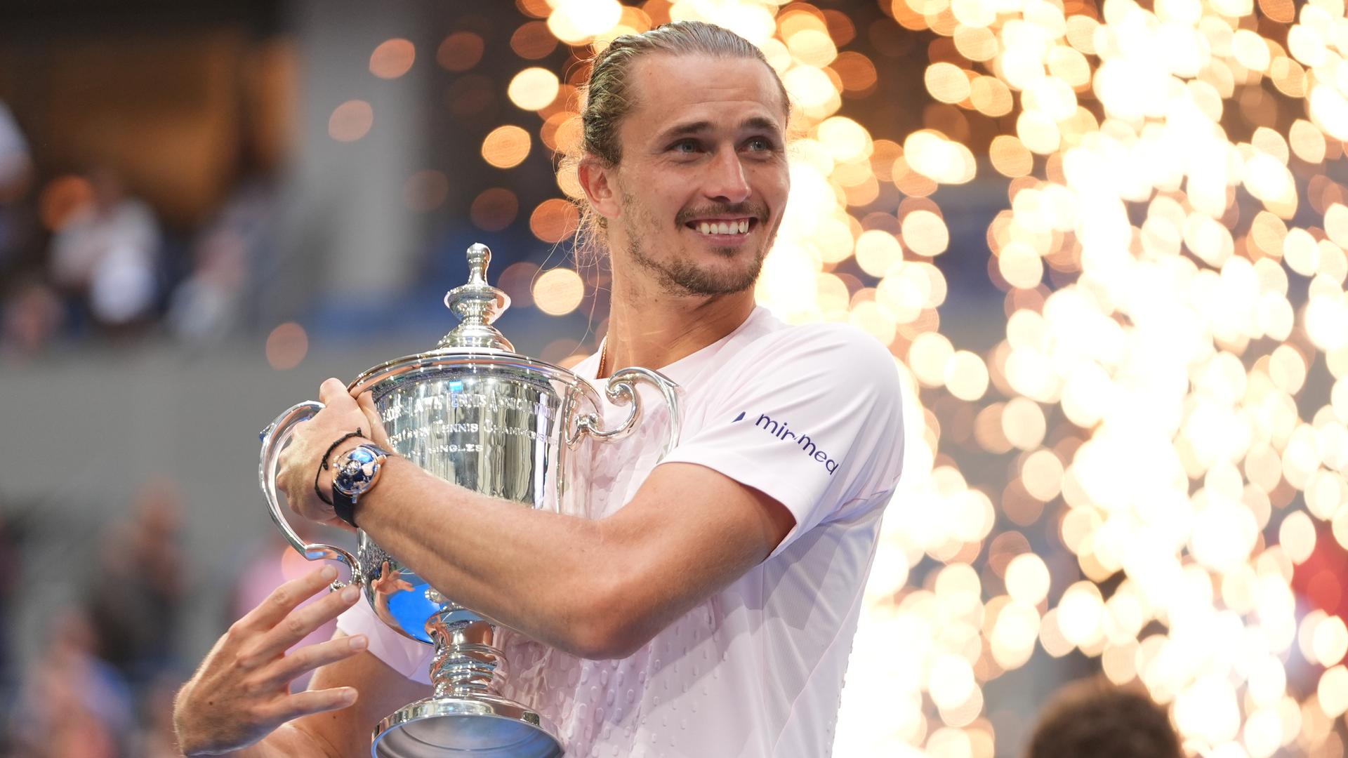 Das Foto zeigt Alexander Zverev mit seinem Sieger-Pokal bei dem Tennis-Turnier US-Open.