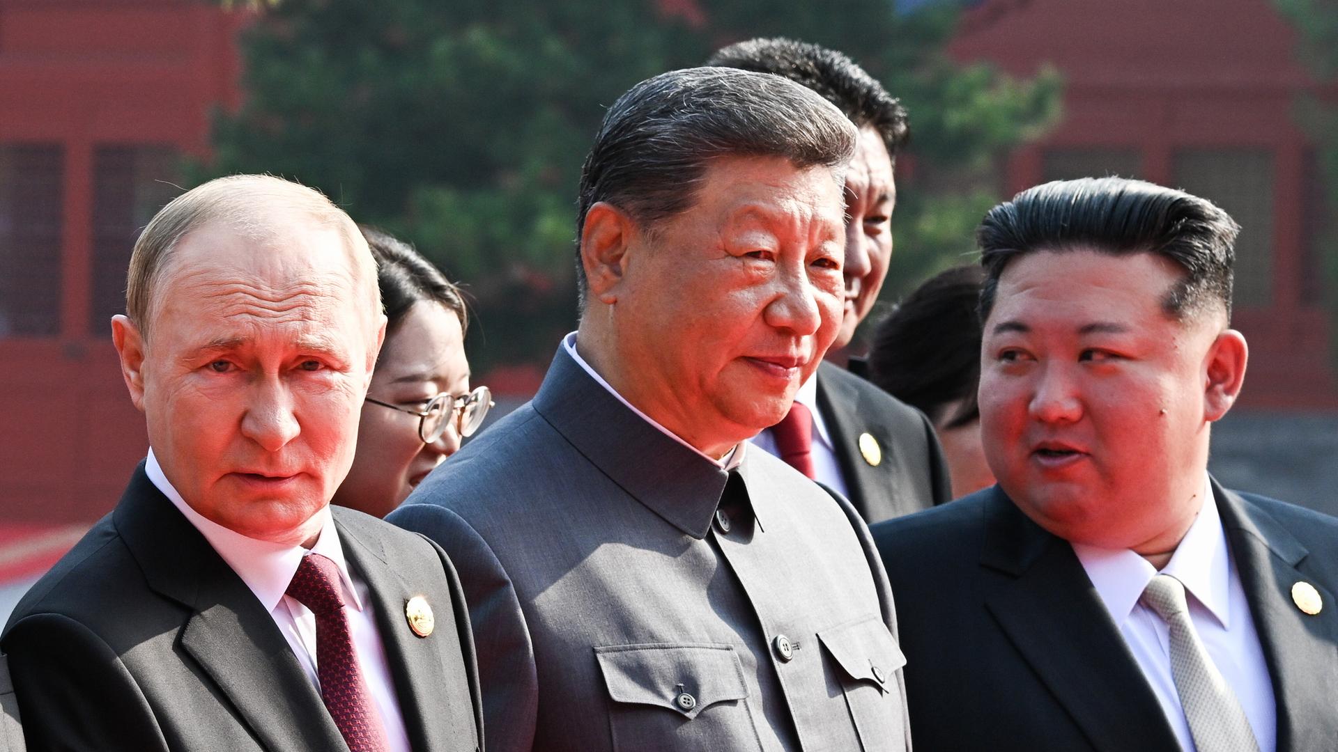Das Bild zeigt Chinas Staatschef Xi Jinping in einem dunklen Anzug, der der Kleidung von Mao Tsetung nachempfunden ist. Neben ihm steht Russlands Präsident Putin und Machthaber Kim Jong Un aus Nordkorea. Das Bild zeigt Chinas Staatschef Xi Jinping in einem dunklen Anzug, der der Kleidung von Mao Tsetung nachempfunden ist. Neben ihm steht Russlands Präsident Putin und Machthaber Kim Jong Un aus Nordkorea.