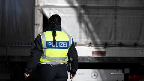 Eine Bundespolizistin steht anlässlich von Grenzkontrollen auf dem Rastplatz "Am Heideholz" an der Autobahn 17 nahe der deutsch-tschechischen Grenze an einem Kleintransporter.