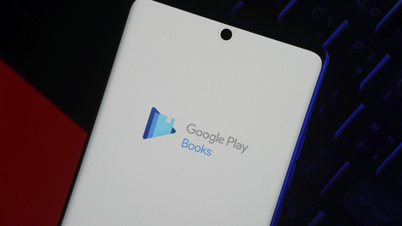 Smartphone mit dem Logo der Google Play Books App auf dem Bildschirm vor einem dunklen Hintergrund