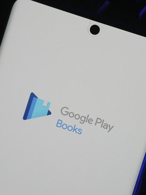 Smartphone mit dem Logo der Google Play Books App auf dem Bildschirm vor einem dunklen Hintergrund