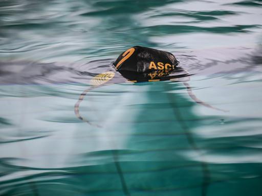 Eine Wasserball-Badekappe mit dem Schriftzug des ASC Duisburg schwimmt auf dem Wasser.