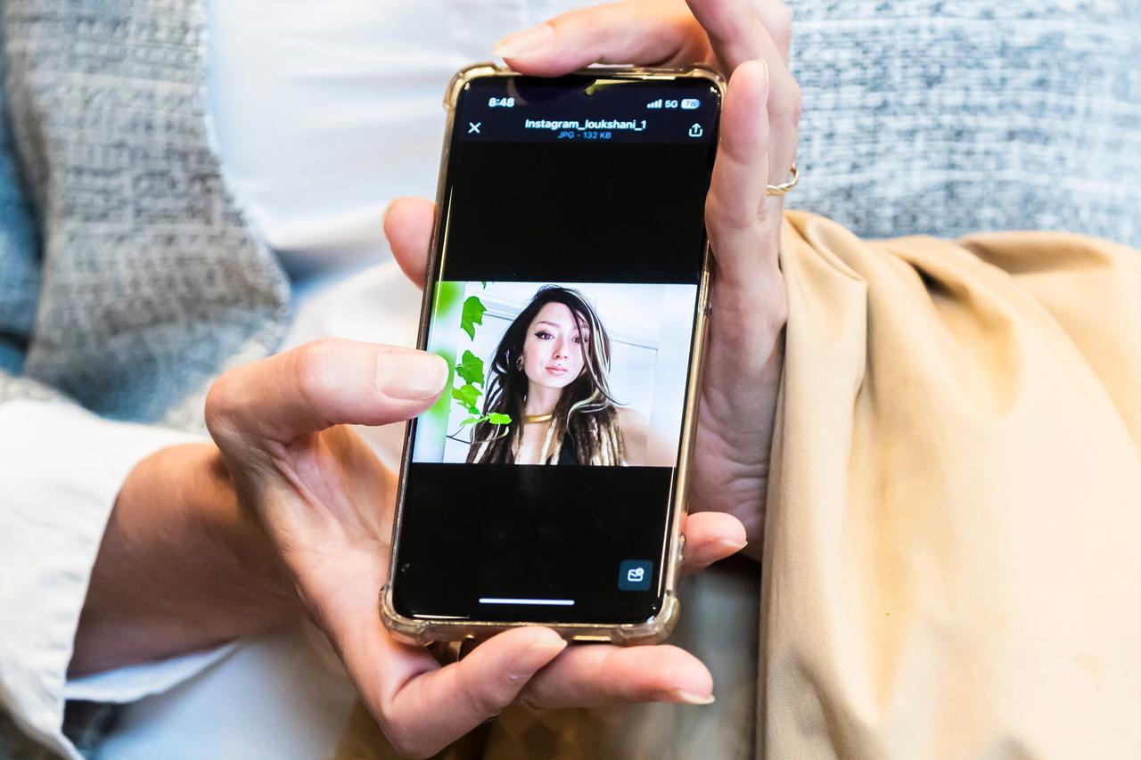 Ricarda Louk zeigt ein Foto ihrer durch die Hamas entführten Tochter Shani Louk. Das Foto auf einem Handy zeigt eine junge Frau mit langen braunen Haaren. 