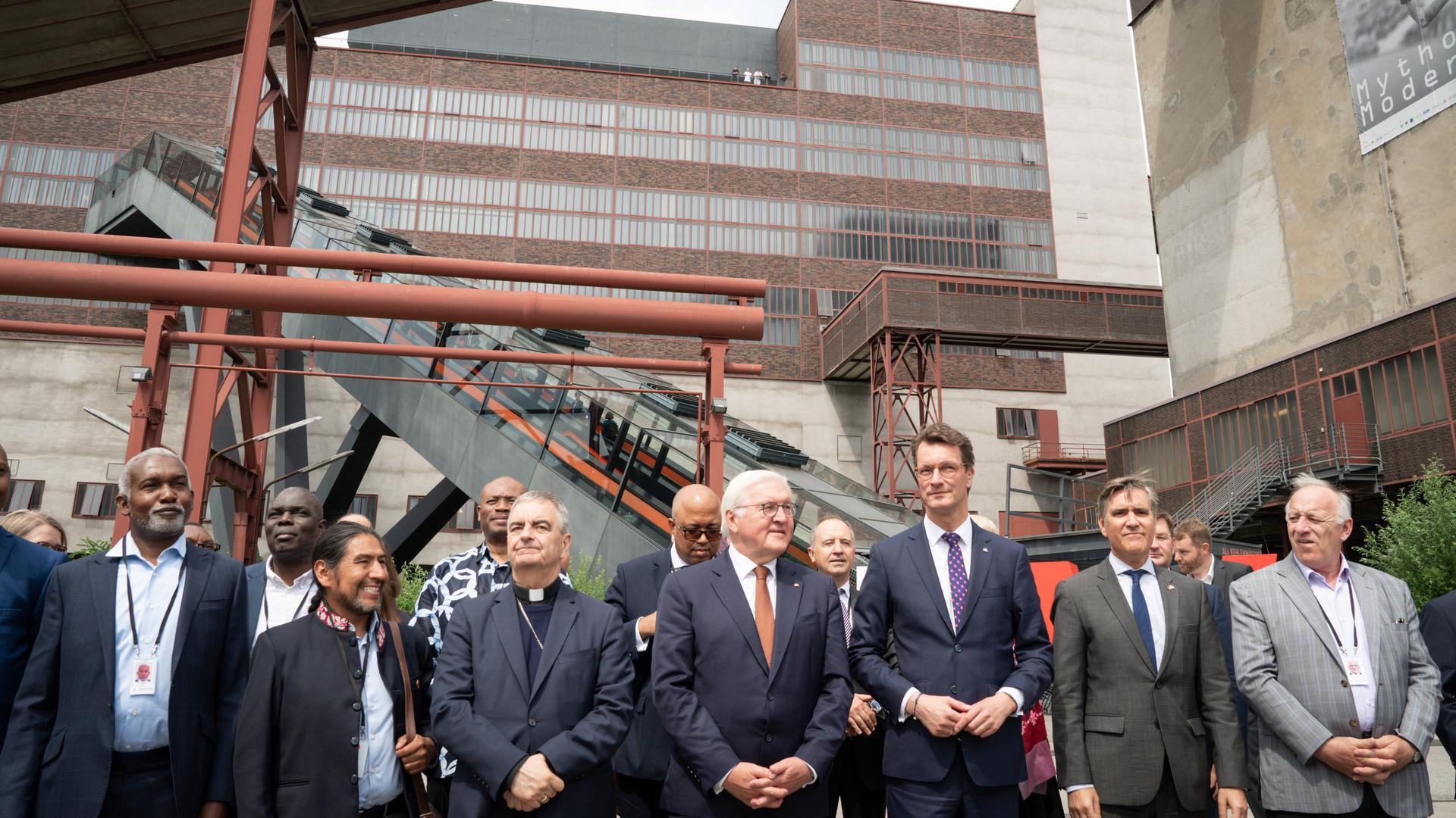 Bundespräsident Steinmeier steht gemeinsam mit anderen Menschen vor der Zeche Zollverein in Essen. Bundespräsident Steinmeier steht gemeinsam mit anderen Menschen vor der Zeche Zollverein in Essen.