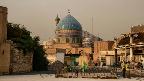 Blick auf eine Moschee mit blauer historischer Kuppel, vor der sich eine Beton-Baustelle eröffnet.