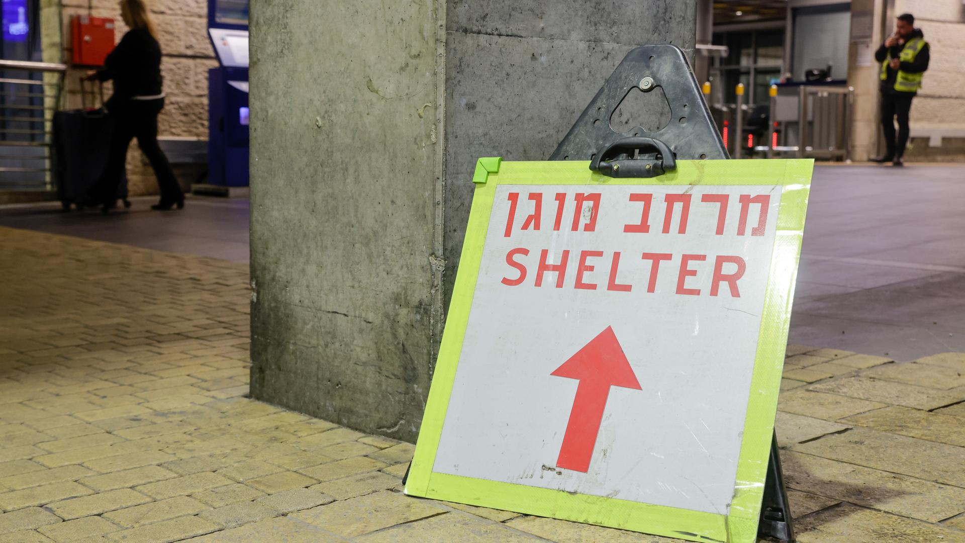 Vor dem leeren Eingang des Flughafens in Tel Aviv ist ein Hinweisschild zu sehen, auf dem "Shelter / Schutzraum" steht.