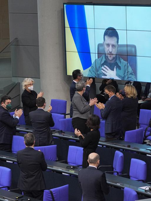 Der ukrainische Präsident Wolodymyr Selenskyj spricht per Videoschalte im Bundestag und bekommt Applaus von der Bundesregierung.