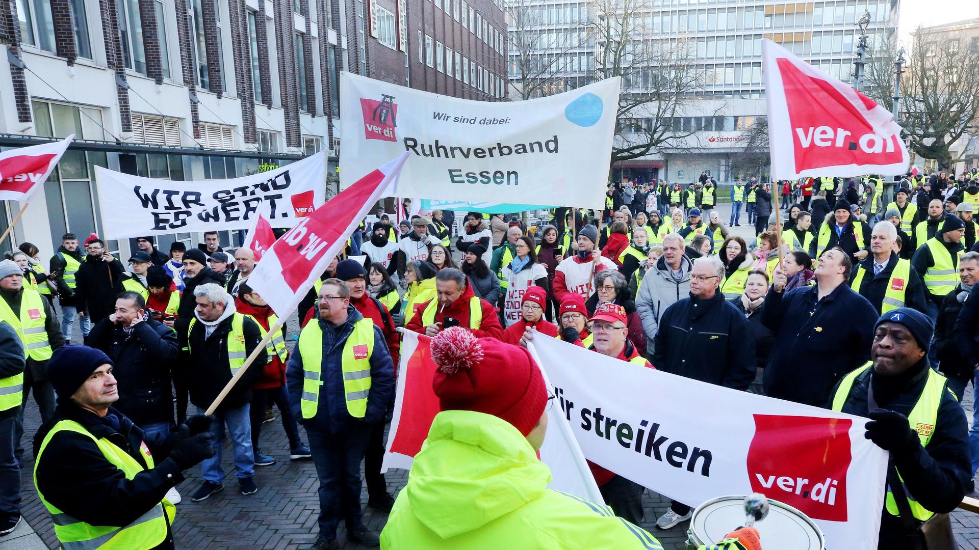 Mit Trommelschlägen und einem Transparent "Wir sind es wert" beteiligen sich Gewerkschaftsmitglieder an einer Streik-Kundgebung von Verdi.