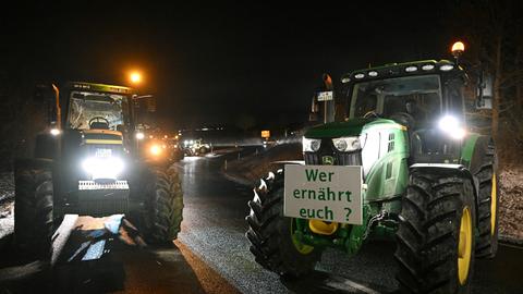 Bauernprotest an einer Autobahnauffahrt am 8. Januar 2024: Zwei Traktoren stehen mitten auf der Fahrbahn, an einem ist ein Schild befestigt mit der Aufschrift "Wer ernährt euch?"