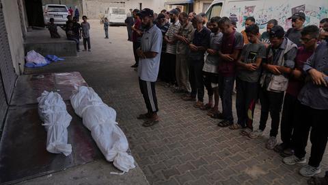 Menschen betrauern die Toten nach dem israelischen Angriff. Sie liegen in weißen Säcken auf dem Boden.