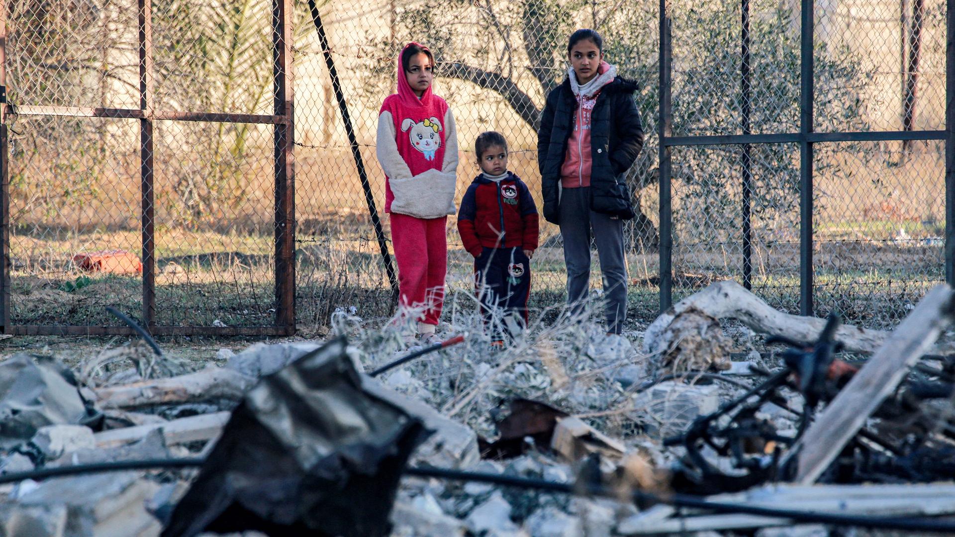 Drei minderjährige Mädchen betrachten die Zerstörungen nach einem israelischen Angriff im südlichen Gazastreifen, östlich von Chan Yunis.