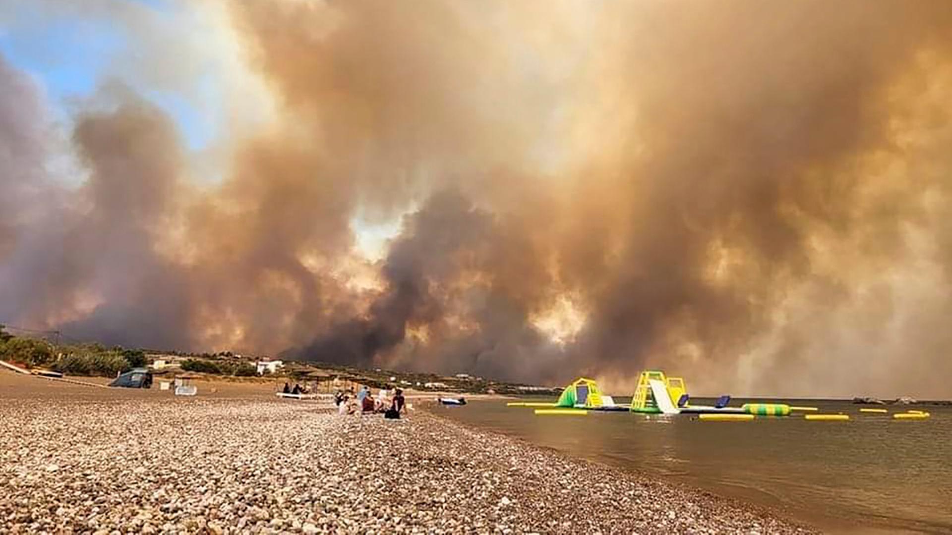 Dichte Rauchwolken eines Waldbrandes steigen auf der griechischen Insel Rhodos in den Himmel.