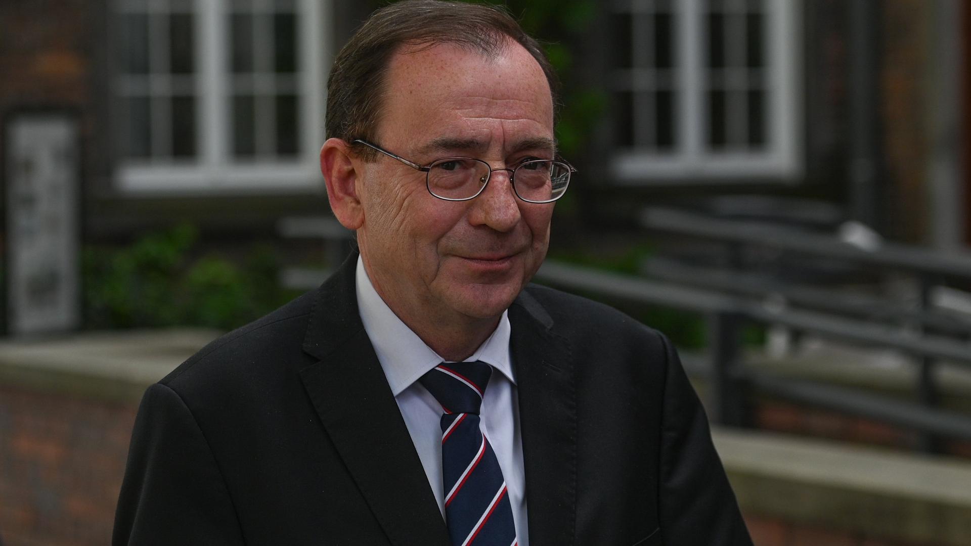 Der polnische Innenminister Kaminski lächelt in die Kamera.