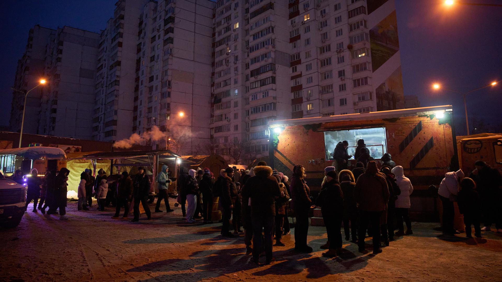 Kiew: Menschen stehen in einer Schlange für kostenlose warme Mahlzeiten an.