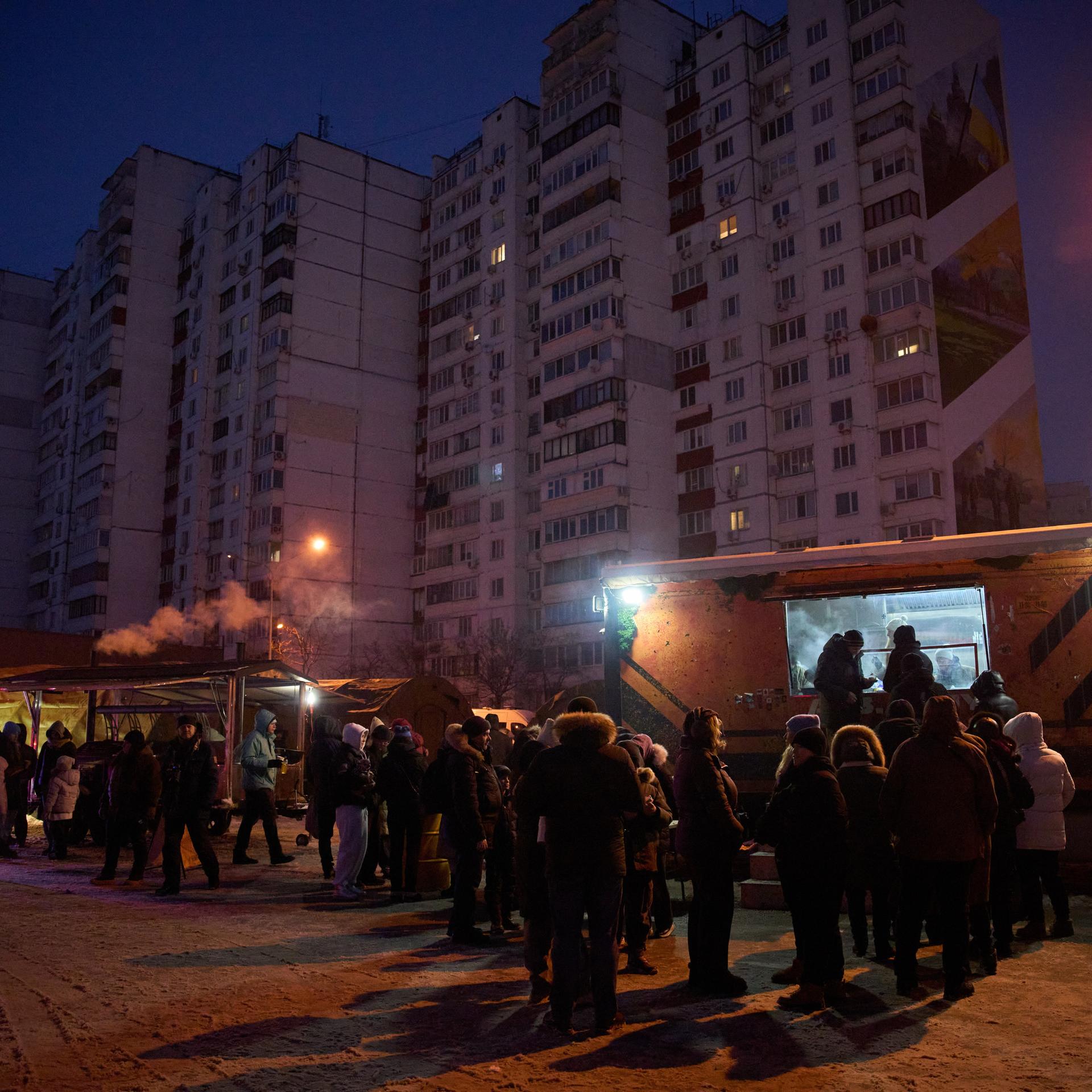Kiew: Menschen stehen in einer Schlange für kostenlose warme Mahlzeiten an.