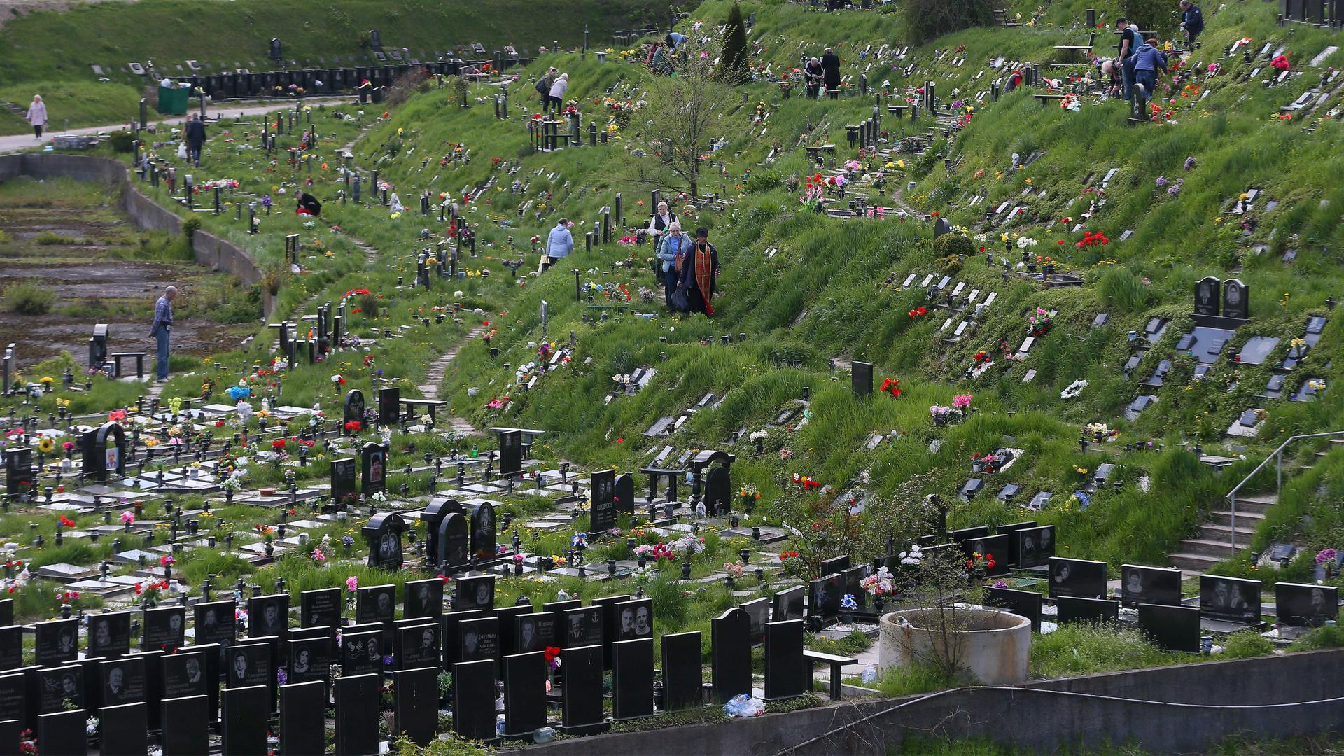 Auch das gehört zum Alltag in Kiew: frische Gräber von Gefallenen und Trauernde auf dem Baikowe-Friedhof