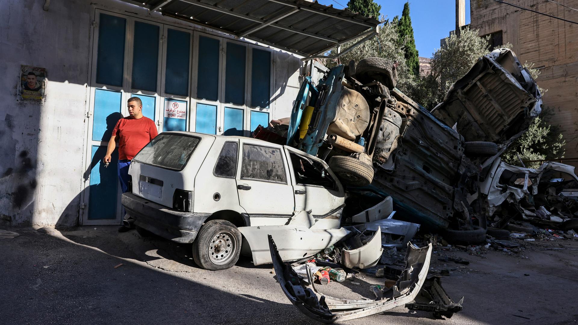 Ein Mann inspiziert von einem israelischen Angriff in der Nacht zerstörte Autos in der Region Nablus. Ein Mann inspiziert von einem israelischen Angriff in der Nacht zerstörte Autos in der Region Nablus.