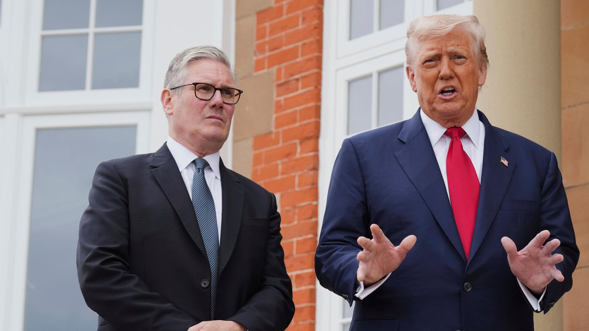 US-Präsident Trump bei einem Treffen mit dem britischen Premierminister Starmer in Schottland. Die beiden stehen nebeneinander, Trump gestikuliert.