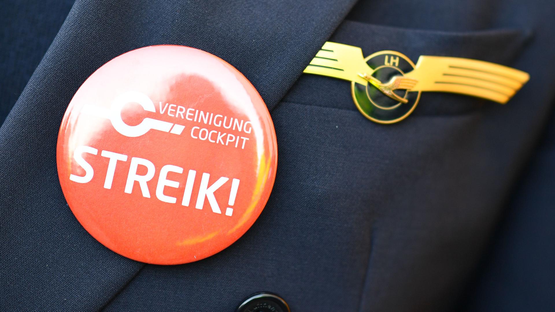 Ein Lufthansa-Pilot trägt bei einer Kundgebung der Pilotengewerkschaft Vereinigung Cockpit einen Button mit der Aufschrift "Streik" auf seiner Uniform. Ein Lufthansa-Pilot trägt bei einer Kundgebung der Pilotengewerkschaft Vereinigung Cockpit einen Button mit der Aufschrift "Streik" auf seiner Uniform.