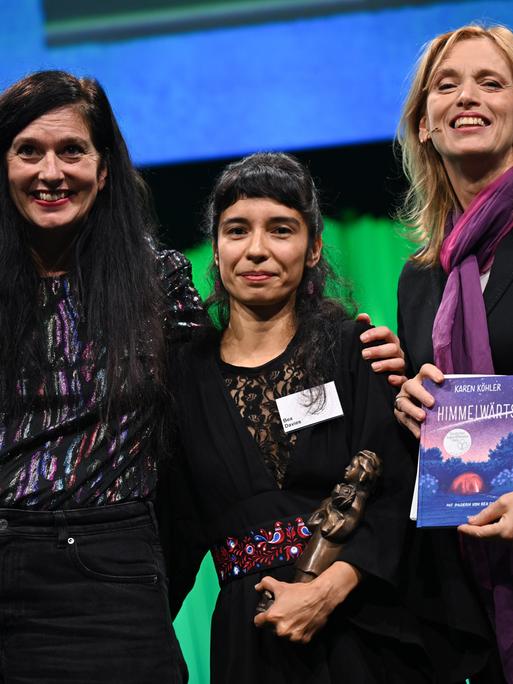 Die Autorin Karen Köhler (l) und die Illustratorin Bea Davies werden bei der Verleihung des Deutschen Jugendliteraturpreis 2025 auf der Frankfurter Buchmesse von Karin Prien mit der Momo-Trophäe ausgezeichnet. 
